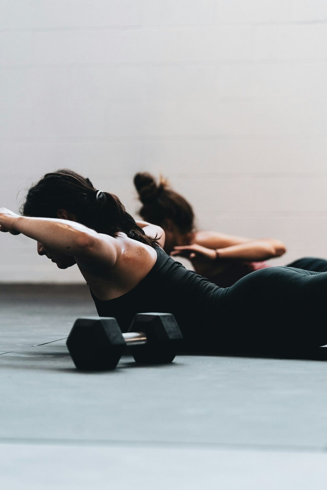 A person doing a supervised floor exercise with a light weight.